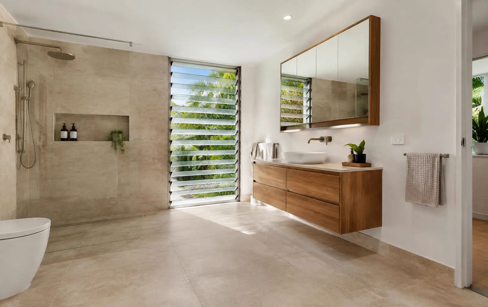 Bathroom renovation in Cairns with walk-in shower, timber vanity and louvre window
